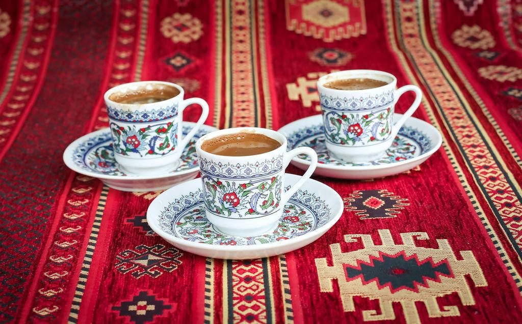 Kırmızı kilim üzerinde desenli fincanlarda Türk kahvesi