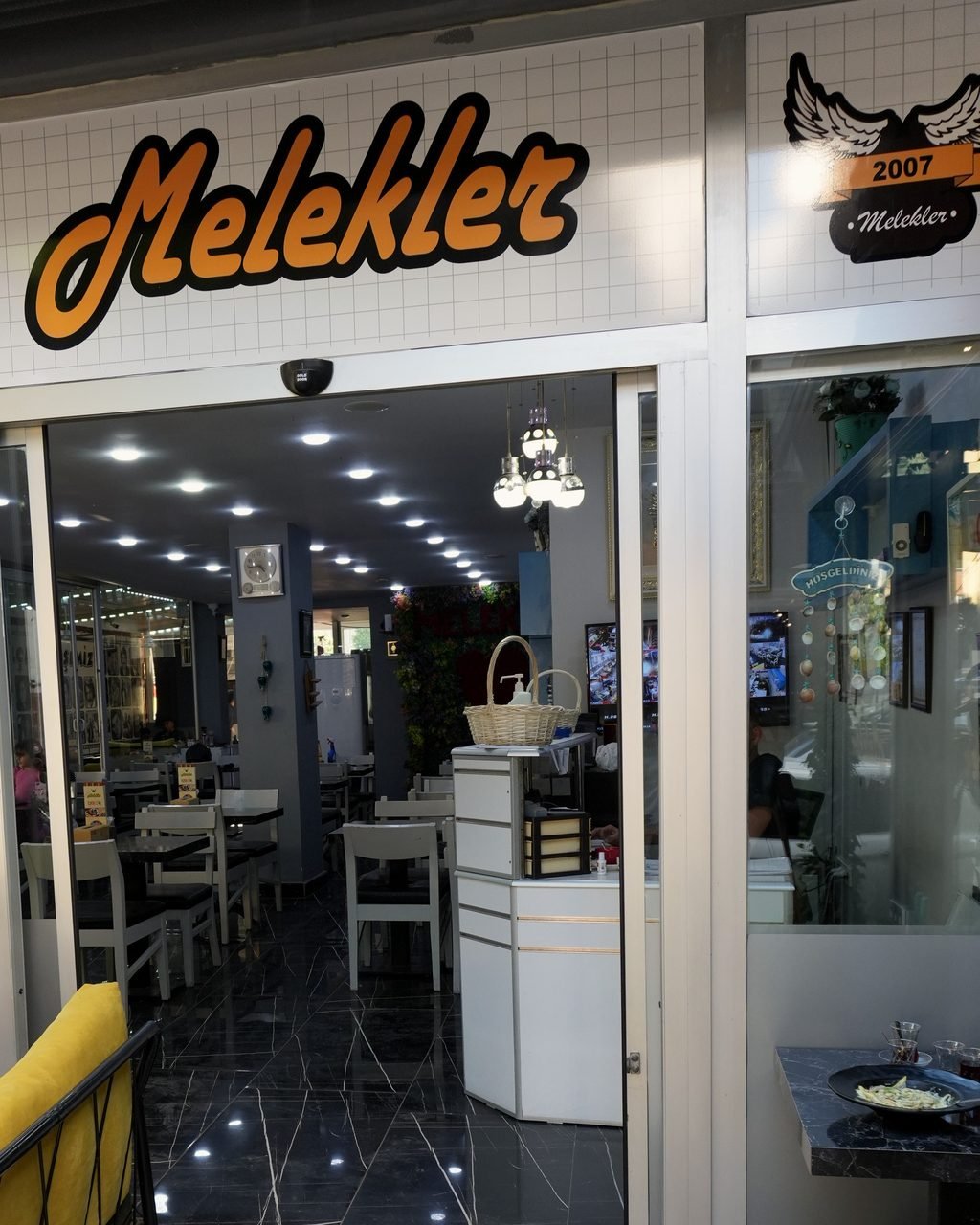 Turuncu Melekler yazılı giriş kapısı ve içeride aydınlık salon